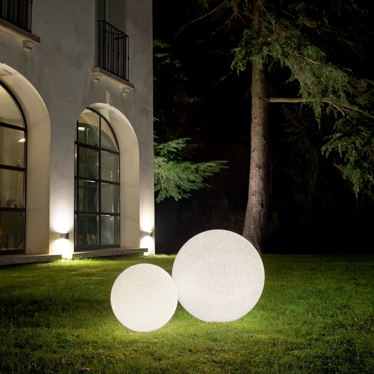 Doris outdoor globe lights on a lawn at night